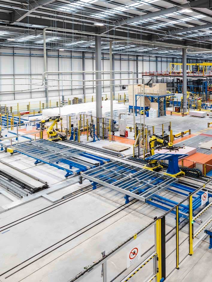 A large industrial facility with automated machinery and protective guard fencing equipped with safety locks. The image highlights the importance of guard locking systems in restricting access to hazardous areas and ensuring worker safety in high-risk environments.