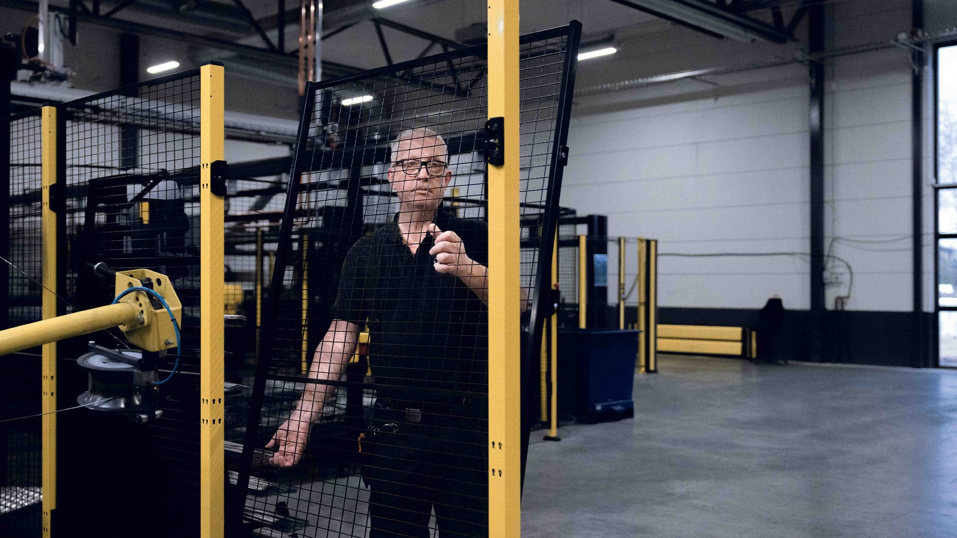 Employee installing Axelent machine guarding in an industrial production environment
